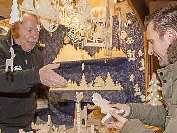 Bürgermeister Andreas Hügerich (r.)testet die Qualität der angebotenen Schnitzereien. Fotos: Klaus Gagel