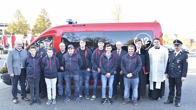 Bekleidet mit ihren neuen Jubiläumsjacken feierten die Mitglieder der Jugendfeuerwehr und ihre Betreuer und Ausbilder mit den Gästen das 20-jährige Bestehen. Links Bürgermeister Claus Bittenbrünn, KBI Peter Pfaff (verdeckt), KBR Ralf Dressel und der Kommandant der Werkfeuer Fränkische, Stefan Burkard, rechts Landrat Wilhelm Schneider, Pfarrer Peter Hohlweg, Kaplan Nicolas Kehl und der Kommandant FFW Königsberg, Peter SchülerGerold Snater