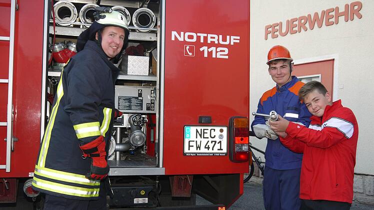 Endlich ran an die Ausrüstung: Erst als Mitglieder der Jugendfeuerwehr dürfen Jungs wie Jan Pertsch (rechts) und Felix Dötschel (Mitte) die ersten Übungen mit wertvoller Ausrüstung machen. Jugendleiter Christian Korn passt dennoch auf, dass nix passiert. Foto: Berthold Köhler