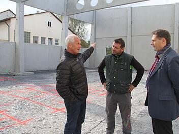 Bürgermeister Roland Wolfrum (rechts) und Schulleiter Michael Pfitzner (links) ließen sich von Uwe Gruner (Mitte) den Fortschritt auf der Baustelle rund um die neue Turnhalle in Stadtsteinach erklären. Die rot eingezeichneten Linien im Hintergrund sind die Markierungen, in denen Vertiefungen eingearbeitet werden. Diese Vertiefungen sind für die Sportgeräte nötig. Foto: Sonny Adam