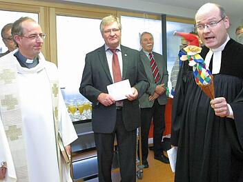 Pfarrer Andreas Neeb (rechts) stieß, von der Kasperle-Figur unterstützt, auf Interesse der Kinder bei der Segnung der Seßlacher Kinderkrippe. Die Feierstunde gestalteten auch Neebs katholischer Kollege Stefan Fleischmann (links) und Bürgermeister Hendrik Dressel mit. Foto: Bettina Knauth