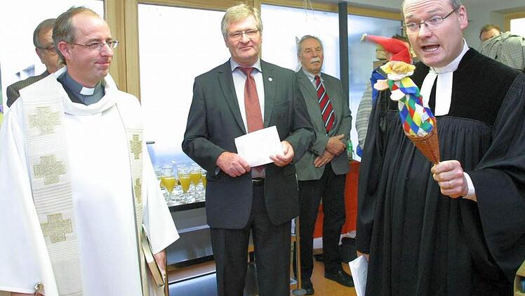 Pfarrer Andreas Neeb (rechts) stieß, von der Kasperle-Figur unterstützt, auf Interesse der Kinder bei der Segnung der Seßlacher Kinderkrippe. Die Feierstunde gestalteten auch Neebs katholischer Kollege Stefan Fleischmann (links) und Bürgermeister Hendrik Dressel mit. Foto: Bettina Knauth