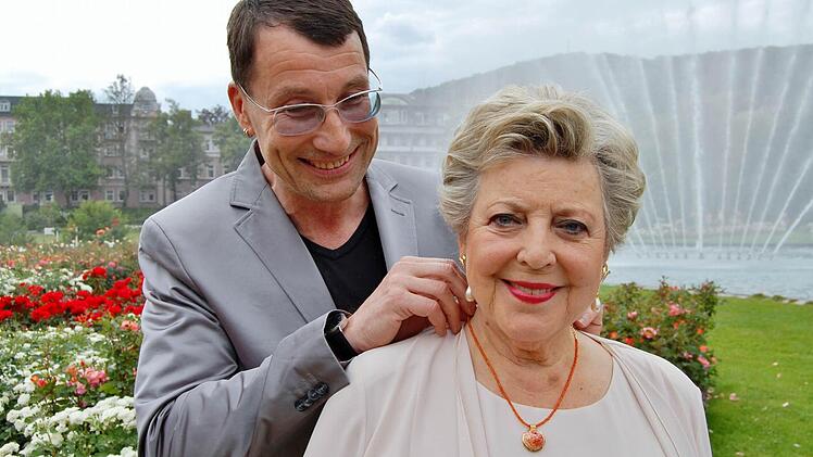 Schmuckdesigner Malte Meinck beschenkt Bad Kissingens neue Botschafterin Marie-Luise Marjan mit einem Rosen-Anhänger aus Porzellan.