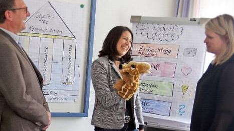 Während des Seminars kommt auch eine "Giraffe" zum Einsatz, mit der GFK-Referentin Katja Reitz (Mitte) dem pädagogischen Leiter der KEB, Stephan Renczes (links), und Lisa Gratzke (rechts) die "Sprache des Herzens" demonstriert.  Foto: Heike Schülein