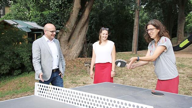 B&uuml;rgermeister Michael Kastl, Allianzmanagerin Hannah Braungart und Alexandra Kehl von der Dorfwerkstatt Wermerichshausen testen die neue Tischtennisplatte, die zu 80 Prozent gef&ouml;rdert wurde.  Foto: Thomas Malz