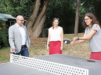 Bürgermeister Michael Kastl, Allianzmanagerin Hannah Braungart und Alexandra Kehl von der Dorfwerkstatt Wermerichshausen testen die neue Tischtennisplatte, die zu 80 Prozent gefördert wurde.  Foto: Thomas Malz