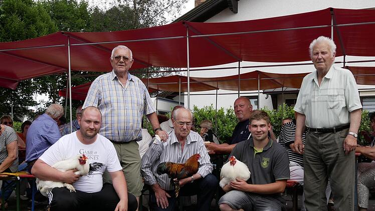 vorne. li. Sascha Schunk, Herbert Lieb mit seinem Sieger-Gockel, Felix Dötschel sowie stehend v. li. Vorsitzender Ernst Fleischmann und Preisrichter Burkhard Pertsch zeigten sich äußerst zufrieden vom Wettstreit der gefiederten Gesellen. Jedenfalls wurde das Sommerfestpublikum damit bestens unterhalten und verbrachte heitere Stunden am Anger. Foto: Manja von Nida