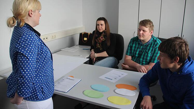 Daniela Kessel (l.) bespricht mit den Auszubildenden (v. l.) Tanja Korb, Robin Zirkelbach und Johannes Schlagenhaft, wie sie das Thema "Outsourcing" von allen Seiten beleuchten können.