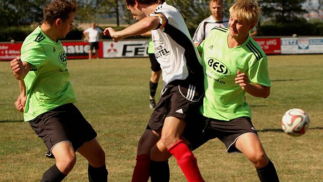 Packender Kampf um den Ball, bei dem die beiden Stettfelder Christian H&ouml;fler (links) und Sebastian Beck (rechts) den Zeller Kapit&auml;n Christoph Herold in die Zange nehmen