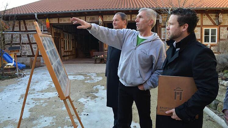 Peter Hofmann zeigt den Gästen anhand einer aufgestellten Fototafel das "Vorher" und "Nachher" der umfangreichen Restaurierung.Das alte Ackerbürgerhaus präsentiert sich im kräftigen roten Ocker.