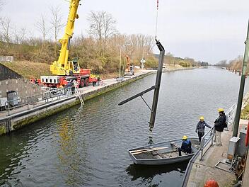 Ein Kran hievt eine Stütze in den Kanal. Den Weg zur Kalotte, in die sich in vier Metern Tiefe der Fuß einhängt, weist ein Taucher.  Fotos: Ronald Rinklef