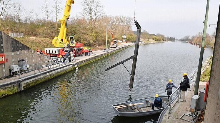 Ein Kran hievt eine Stütze in den Kanal. Den Weg zur Kalotte, in die sich in vier Metern Tiefe der Fuß einhängt, weist ein Taucher.  Fotos: Ronald Rinklef