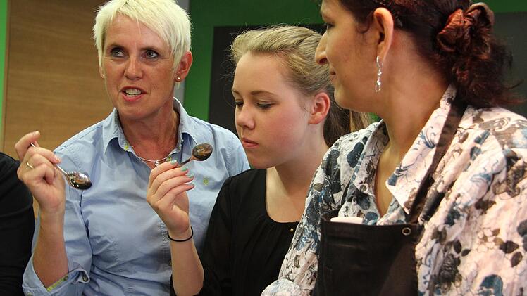 Elke und Amelie Brehm schauen Zöhre Özhan über die Schulter und schmecken den rohen Reis mit den Gewürzen ab.