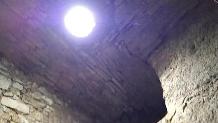 Vom Boden des vom Schutt befreiten Lochgef&auml;ngnisses sieht man oben das kreisrunde "Angstloch" als Zugang. Foto: Jochen Scherbaum