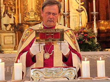 Msgr.Georg Holzschuh erteilt mit dem Reliquienschrein den Segen. Foto: Blum