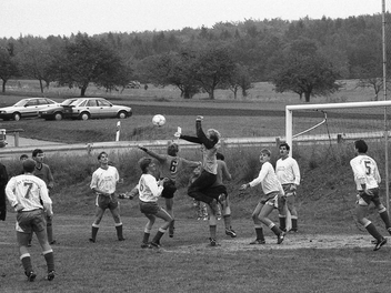 Auto-Modelle und Haar-Mode weisen deutlich auf die 80er Jahre hin. Anfang Oktober 1989 duellieren sich der TSV Wollbach und der FSV Schönderling. Foto: E.E. Kunstmann