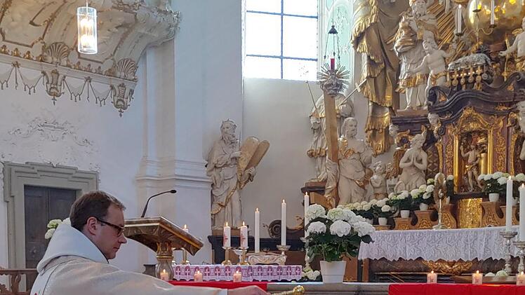 In einer fast menschenleeren Basilika Gößweinstein segnet Pfarrer  Pater Ludwig Mazur während des Oster-Festgottesdienstes die Osterspeisen vor  dem Altar.  Foto: Thomas Weichert