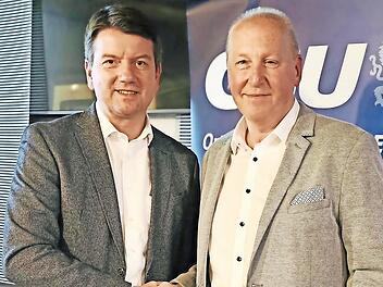 Von links: Staatssekretär Sandro Kirchner gratuliert dem wiedergewählten Vorsitzenden Detlef Heim.