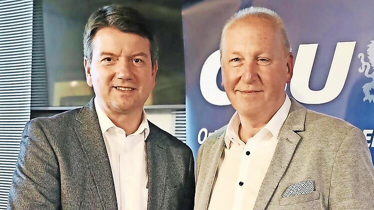 Von links: Staatssekretär Sandro Kirchner gratuliert dem wiedergewählten Vorsitzenden Detlef Heim.