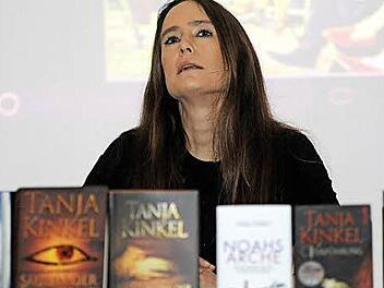 Tanja Kinkel hinter einer selbst geschriebenen Bücherwand  Foto: Ölschlegel