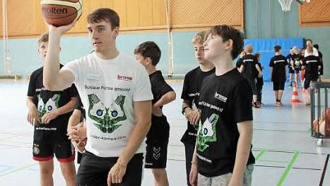 Coach Felix zeigt Joshua die richtige Wurftechnik.