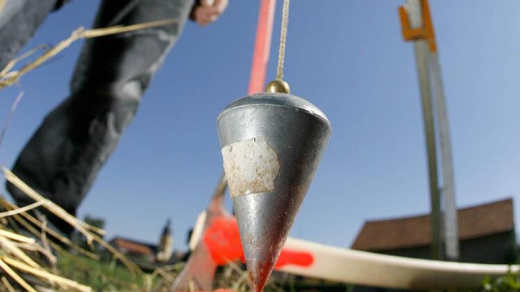 Feldgeschworene benutzen unter anderem ein Steinsetzgerät, um auf den Zentimeter genau die Koordinaten eines Grenzsteins (rot markiert) festzulegen. Foto: dpa/Daniel Karmann