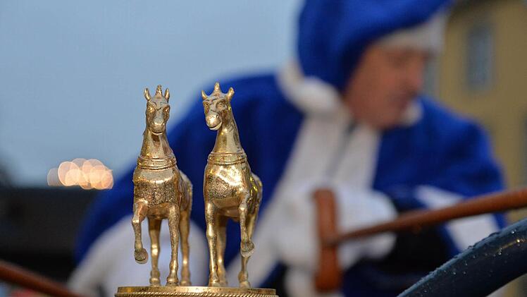 Zwei goldene Pferde an der Auto-Kutsche
