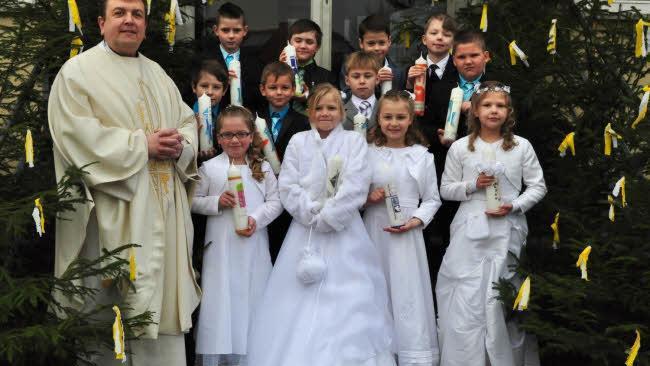 Pfarrweisach &mdash; In der Pfarrkirche St. Kilian Pfarrweisach haben am Wei&szlig;en Sonntag vier M&auml;dchen und acht Buben aus der Pfarrei Pfarrweisach das Fest der Heiligen Kommunion gefeiert. Unser Bild zeigt sie zusammen mit Pater Michael Stutzig (links).  Foto: Simon Albrecht