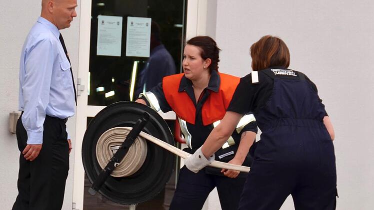 Beim Aufräumen nach dem Test: Sabrina Schmitt und Silvia Gärtner wickeln einen Schlauch auf, begleitet vom stellvertretenden Kommandant Steffen Schade. Foto: Kathrin Kupka-Hahn