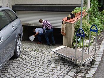Die Sachverständigen schlüpfen unter dem bereits halb geschlossenen Rolltor in den Keller des Alten Schützenhauses. Fotos: Oliver Schmidt