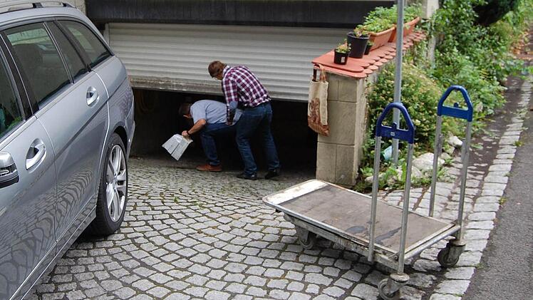 Die Sachverständigen schlüpfen unter dem bereits halb geschlossenen Rolltor in den Keller des Alten Schützenhauses. Fotos: Oliver Schmidt