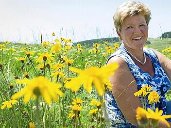 Bürgermeisterin Gabriele Weber inmitten einer Arnika-Wiese. Sie verspricht sich von der neuen Arnika-Akademie in ihrer Stadt neue Impulse für die Zukunft.  Foto: Reinhard Feldrapp