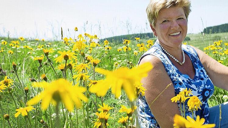 Bürgermeisterin Gabriele Weber inmitten einer Arnika-Wiese. Sie verspricht sich von der neuen Arnika-Akademie in ihrer Stadt neue Impulse für die Zukunft.  Foto: Reinhard Feldrapp