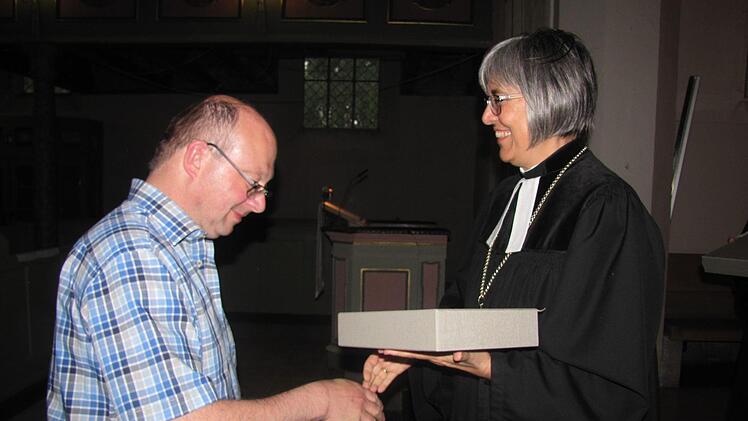 Bernd Brückner nimmt aus der Hand von Regionalbischöfin Dr. Dorothea Greiner die neue Altarbibel für die St.-Matthäus-Kirche in Neuses entgegen. Foto: Martin Koch