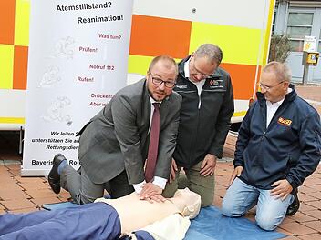 Die beiden erfahrenen Rettungsdienstler Volker Drexler-Löffler und Albert Florschütz zeigen Landrat Sebastian Straubel die richtige Herz-Lungen-Wiederbelebung.  Foto: Michael Stelzner