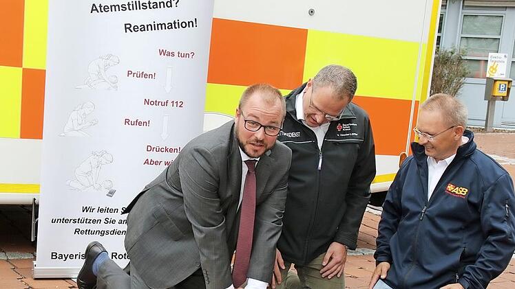 Die beiden erfahrenen Rettungsdienstler Volker Drexler-Löffler und Albert Florschütz zeigen Landrat Sebastian Straubel die richtige Herz-Lungen-Wiederbelebung.  Foto: Michael Stelzner