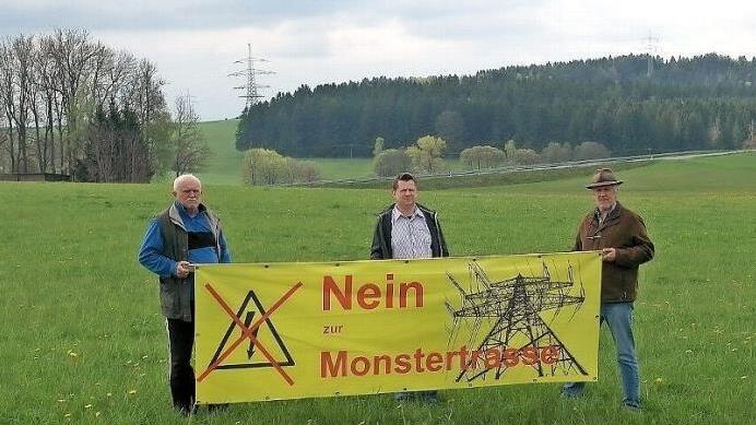 Der Sprecher der Bürgerinitiative Neuensorg, Fritz Ruppert, Josef Pittroff und Axel Bochnia aus Mittelrehberg (von links) haben sich mit ihrem Transparent oberhalb des Weilers Vorderrehberg postiert. Dort soll die Nord-Variante des Ostbayernrings verlaufen. Foto: Peter Müller