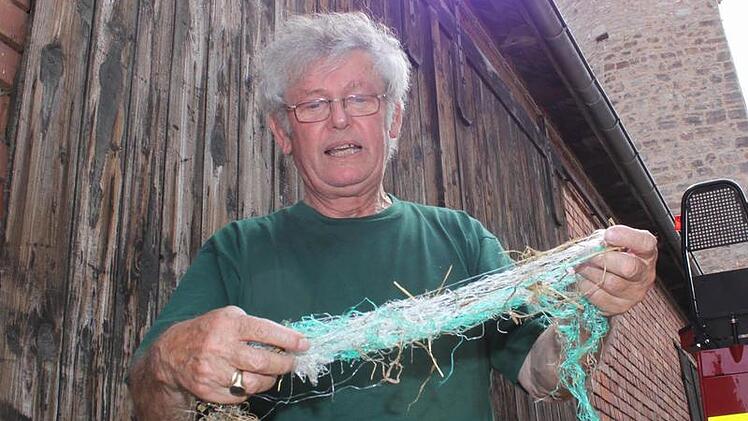 Jochen Willecke vom Bund Naturschutz zeigt das Netz, das er aus Sicherheitsgr&uuml;nden aus dem Storchennest entfernt hat.