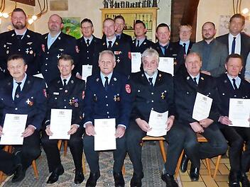 Die Geehrten, vorne sitzend die "40-Jährigen", mit den Feuerwehrführungskräften, Landrat Hermann Ulm, Bürgermeisterin Christiane Meyer und ihrem Stellvertreter Sebastian Götz  Foto: Thomas Weichert