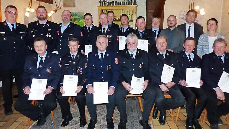 Die Geehrten, vorne sitzend die "40-Jährigen", mit den Feuerwehrführungskräften, Landrat Hermann Ulm, Bürgermeisterin Christiane Meyer und ihrem Stellvertreter Sebastian Götz  Foto: Thomas Weichert