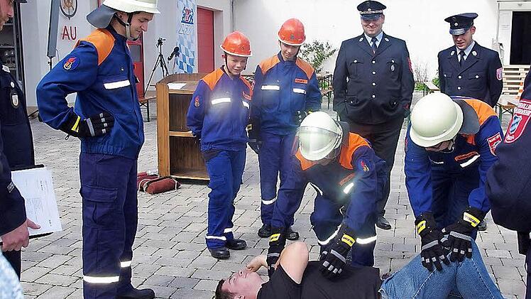 Die Nachwuchs-Feuerwehrkräfte Dirk Fischer, Jakob Welscher, Markus Müller, Lukas Müller und Kevin Barnickel bringen den "Verletzten" Felix Boxdörfer in die stabile Seitenlage.  Foto: Heike Schülein