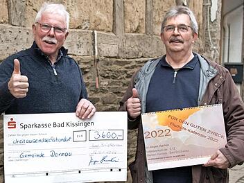 J&uuml;rgen Hurrlein (rechts) &uuml;bergab seine Spende an Alfred Sebastian, B&uuml;rgermeister von Dernau, vor der &ouml;lverseuchten Wand eines Hauses, das wohl abgerissen werden muss.