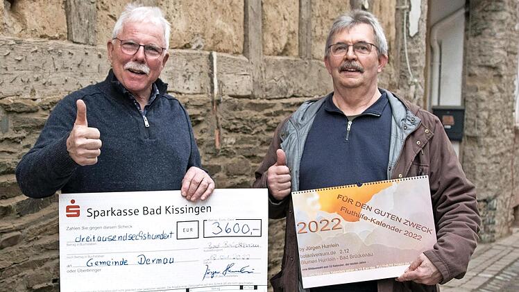 J&uuml;rgen Hurrlein (rechts) &uuml;bergab seine Spende an Alfred Sebastian, B&uuml;rgermeister von Dernau, vor der &ouml;lverseuchten Wand eines Hauses, das wohl abgerissen werden muss.