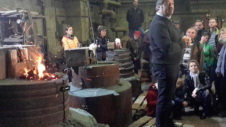 Nur noch eine kleine Flamme züngelt über der Gussform (links). Für Firmenchef Hanns Martin Rincker (Bildmitte) ist das ein untrügliches Zeichen für den erfolgreichen Verlauf der gesamten Aktion. Foto: Rolf Pralle