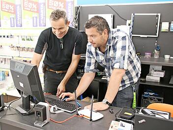 Arno Reuscher (links) und Daniel Michel testen das WLAN, das ab sofort zur Verfügung steht. Der Router wird in den Schaufenstern aufgestellt, damit sie den Innenraum der Geschäfte und das Areal vor den Läden abdecken.  Foto: Thomas Malz