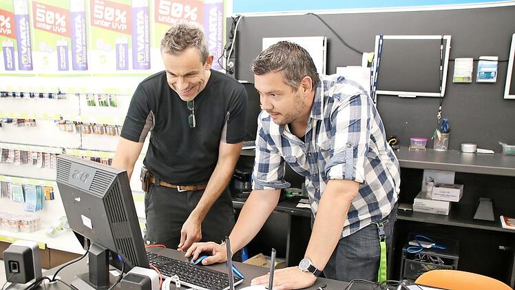 Arno Reuscher (links) und Daniel Michel testen das WLAN, das ab sofort zur Verfügung steht. Der Router wird in den Schaufenstern aufgestellt, damit sie den Innenraum der Geschäfte und das Areal vor den Läden abdecken.  Foto: Thomas Malz