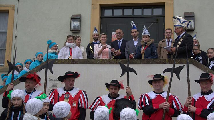 Sophia Gromhaus (Hafenpreppach) und Marcel Meixner (Oberelldorf) regieren als Sophia I und Marcel III. in dieser Session die Seßlacher Narren. Am gestrigen Sonntag übernahmen sie symbolisch den Rathausschlüssel aus der Hand des kommissarischen Bürgermeisters Wolfgang Pfister (Bildmitte zwischen ihnen). Ein Kinderprinzenpaar sucht Faschingspräsident Jens-Peter Scholz (oben rechts) noch. Wegen der Rathaussanierung die "Machtübernahme" in diesem Jahr vor der Alten Schule statt. Foto: Bettina Knauth