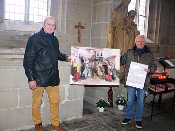 Die Organisatoren (von links) Werner Müller und Siegfried Schneider bringen Krippen-Bilder in der St.-Anna-Kapelle an.Heike Schülein