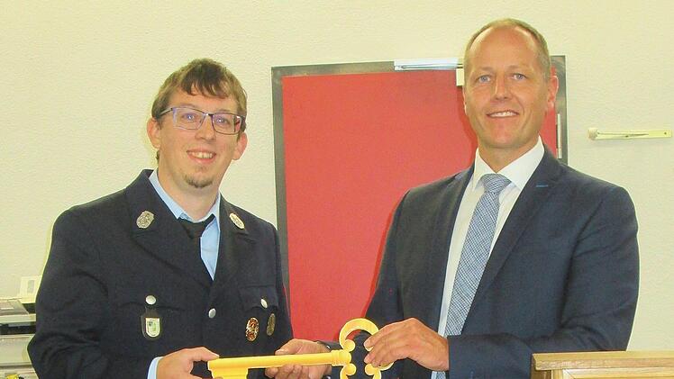 Bürgermeister Johannes Krumm   übergab den symbolischen Schlüssel für den Neubau an Feuerwehrkommandant  Dominik Roth. Foto: Winfried Ehling