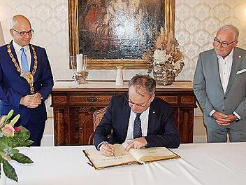 Tschechiens Botschafter in Deutschland Tomá&scaron; Kafka trägt sich unter den Augen von Oberbürgermeister Dirk Vogel und Bürgermeister Thomas Leiner ins Goldene Buch ein.